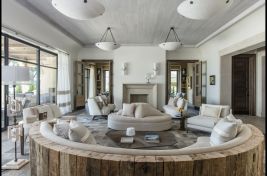 Fabulous custom upholstered curved sectional with wood back in a luxurious Tuscan modern inspired space, decorated by Penny Drue Baird of Dessins. Upholstery: Bespoke by Luigi Gentile